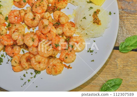 Grilled prawns and cooked rice with slices of lemon and chopped basil. Food photography. Bio healthy recipe Grilled prawns and cooked rice with slices of lemon and chopped basil. Food photography. Bio healthy recipe 112307589