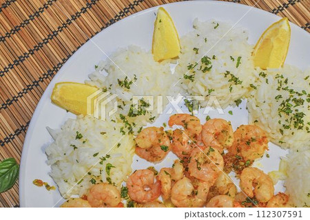 Grilled prawns and cooked rice with slices of lemon and chopped basil. Food photography. Bio healthy recipe Grilled prawns and cooked rice with slices of lemon and chopped basil. Food photography. Bio healthy recipe 112307591