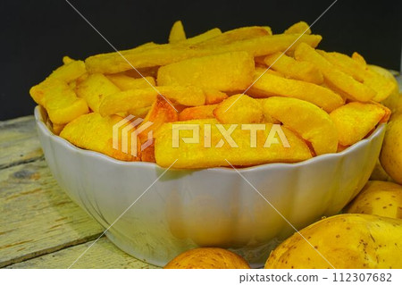 Homemade baked potato fries on white wooden board Homemade baked potato fries on white wooden board 112307682