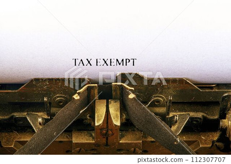 Closeup on vintage typewriter. Front focus on letters making TAX EXEMPT text. Business concept image with retro office tool 112307707