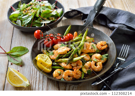 Fried green asparagus with tiger prawns and fresh coriander leaves, served with a Swiss chard salad Fried green asparagus with tiger prawns and fresh coriander leaves, served with a Swiss chard salad 112308214