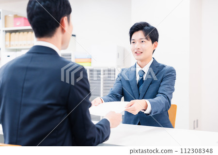 商人在櫃檯交換紙本文件 112308348