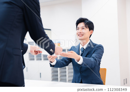 Businessmen exchanging paper documents at the counter 112308349