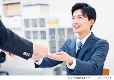 商人在櫃檯交換紙本文件 商人在櫃檯交換紙本文件 112308351