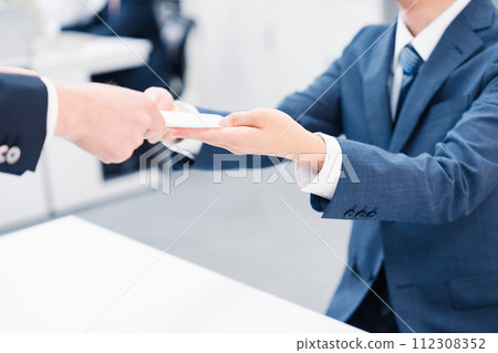 商人在櫃檯交換紙本文件 112308352