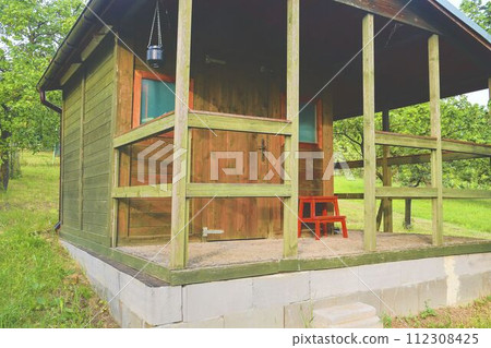 Small house cabin shed. Cute summer cabin in rural orchard. 112308425