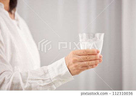 中間女人的手拿著一杯水 112310036