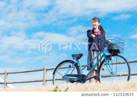Girls going to school by bicycle Girls going to school by bicycle 112310635