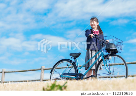 Girls going to school by bicycle 112310636