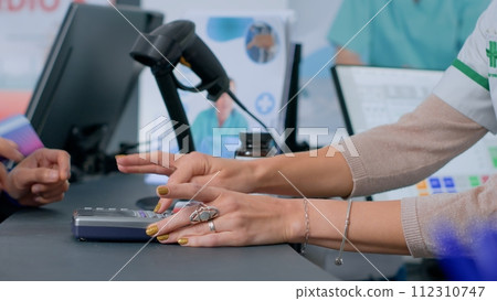 Close up shot of client in drugstore at checkout counter using credit card to purchase prescribed medicaments. Customer doing contactless paying in apothecary after finding needed disease remedy pills 112310747