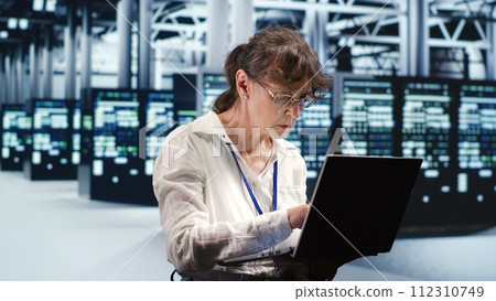 Proficient system administrator looking around revolutionary data center, preparing to start comission on damaged high tech server rackmounts in order to ensure ideal operations 112310749