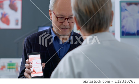 Senior man at pharmacy counter, showing druggist cardiologist prescribed pills, ready to buy them. Aged healthcare expert selling client required medication drug to alleviate sickness 112310765