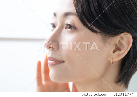 A woman receiving sunlight from the window A woman receiving sunlight from the window 112311774