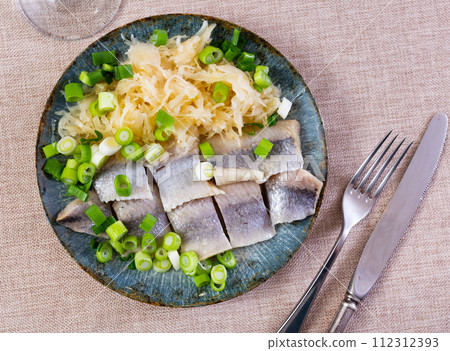 Sliced herring served with sauerkraut 112312393