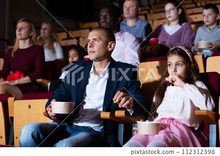 Family watching a movie in cinema hall Family watching a movie in cinema hall 112312398