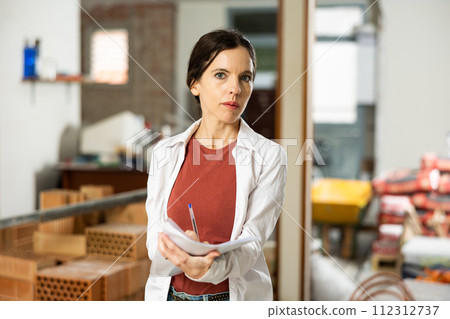 Motivated woman making notes on home space planning during renovation 112312737