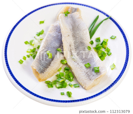 Tasty lightly salted herring served with onion slices on plate 112313079