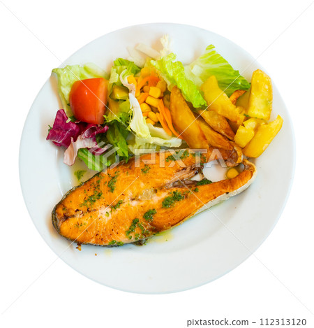 On plate, slice of fried salmon garnished with French fries and salad of fresh vegetables On plate, slice of fried salmon garnished with French fries and salad of fresh vegetables 112313120