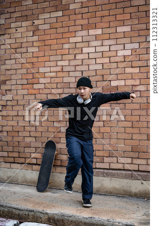 A cool Asian man in fashionable clothes is dancing on the street, practicing his breakdance outdoors A cool Asian man in fashionable clothes is dancing on the street, practicing his breakdance outdoors 112313321