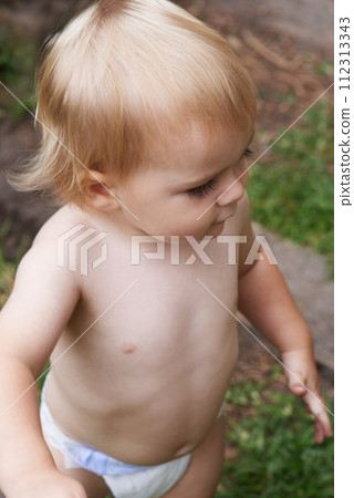 Baby, playing and home in outdoor, development and growth for curiosity, backyard and diaper. Toddler, child and face in garden, alone and childhood memories for wellness, milestone and exploring 112313343