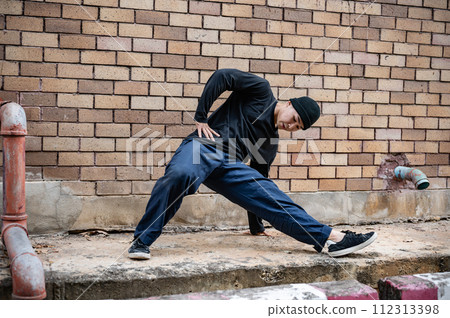 A cool Asian male hip-hop breakdancer is dancing on the street, showcasing his talented movements. A cool Asian male hip-hop breakdancer is dancing on the street, showcasing his talented movements. 112313398