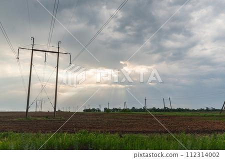 [烏克蘭] 頓巴斯地區，陽光透過多雲天空的縫隙照射到平原上，電線桿與電線相連 112314002