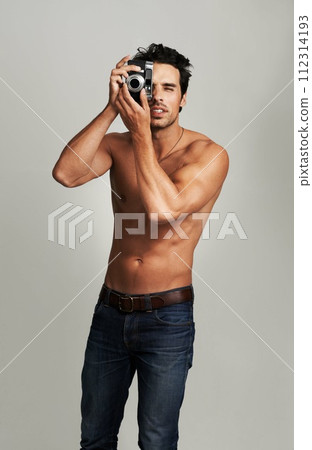 Camera, shirtless and young man in a studio with art, creative and photography career. Confused, doubt and attractive male photographer from Canada with dslr equipment isolated by gray background. 112314193