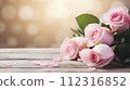 Light pink roses against a soft-focus background with a wood for 112316852