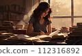 A young woman sits at a desk in a library, surrounded by books. 112316892