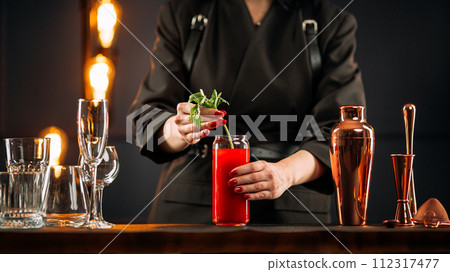Woman making bloody mary cocktail with celery Woman making bloody mary cocktail with celery 112317477