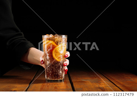 Woman holding glass of long island ice tea Woman holding glass of long island ice tea 112317479
