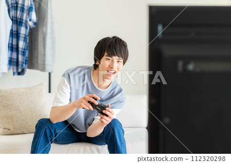 在客廳玩電子遊戲的年輕人 112320298