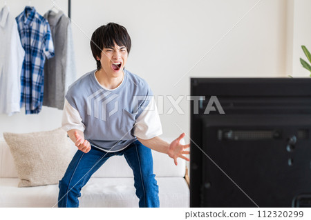 年輕人在客廳裡看電視 112320299