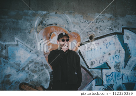 Man smoking in front of street art 112320389
