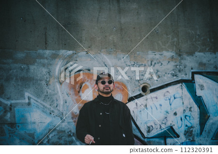 Man smoking in front of street art Man smoking in front of street art 112320391
