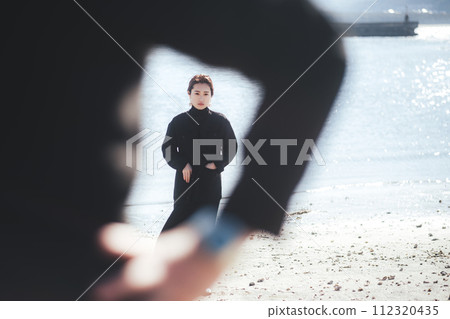 在海灘上站在男人身後的女人 在海灘上站在男人身後的女人 112320435