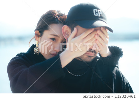Woman hiding man's eyes at the beach Woman hiding man's eyes at the beach 112320461