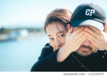 女人在沙灘上遮住男人的眼睛 112320471