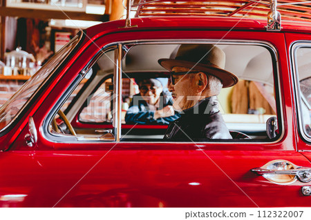 A picture of a senior couple having a conversation over their car 112322007