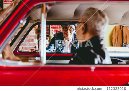 A picture of a senior couple having a conversation over their car 112322018