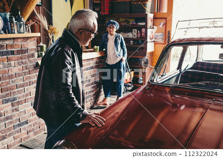 A picture of a senior couple having a conversation while looking at their car A picture of a senior couple having a conversation while looking at their car 112322024