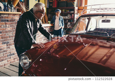 A picture of a senior couple having a conversation while looking at their car A picture of a senior couple having a conversation while looking at their car 112322028