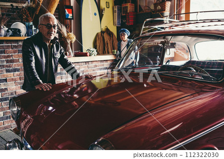 A picture of a senior couple having a conversation while looking at their car 112322030