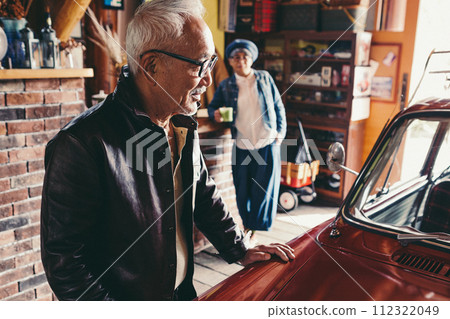 A picture of a senior couple having a conversation while looking at their car A picture of a senior couple having a conversation while looking at their car 112322049