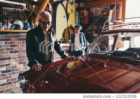A picture of a senior couple having a conversation while looking at their car A picture of a senior couple having a conversation while looking at their car 112322056
