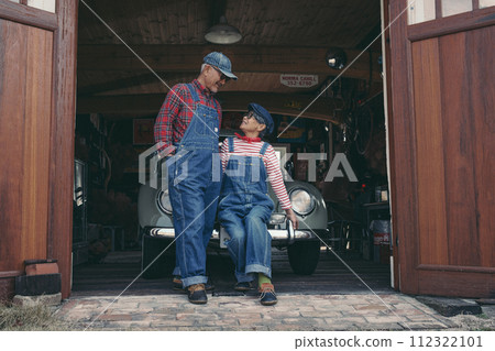 Fashion photo of a senior couple standing with their car in front of the garage 112322101