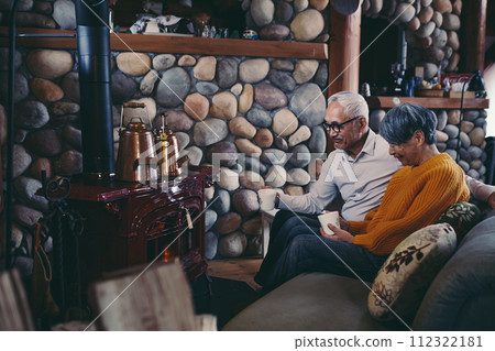 一對老年夫婦和睦地坐在沙發上的照片 一對老年夫婦和睦地坐在沙發上的照片 112322181