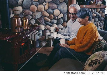 A picture of a senior couple sitting on a sofa in harmony 112322196