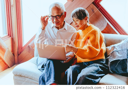 A picture of a senior couple doing a video call 112322416