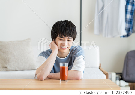 A young man drinking vegetable juice 112322490